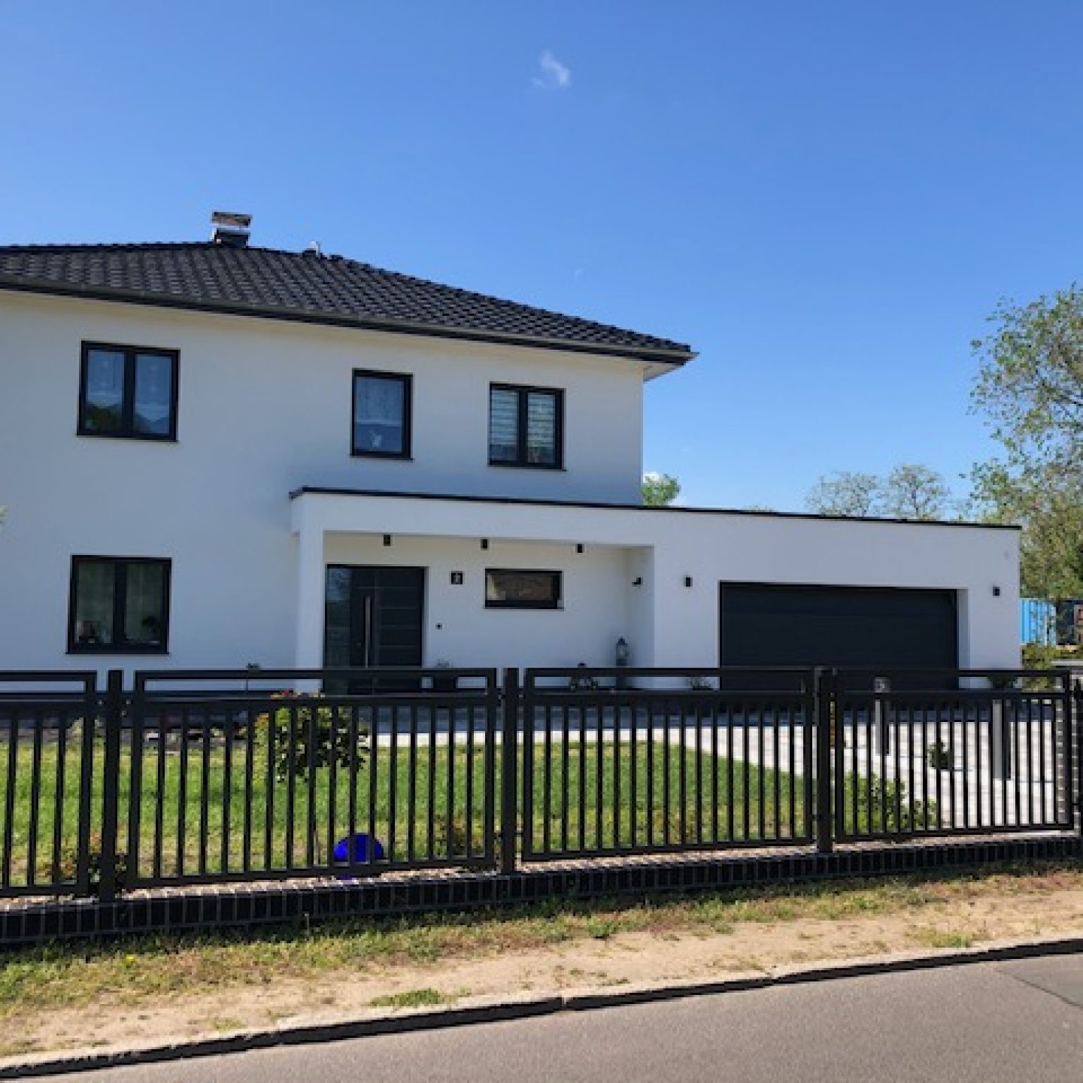 Einfamilienhaus mit Garage und Zaun